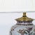 This table lamp features a ceramic base with a detailed floral pattern in soft colors. It includes a classic cream-colored...