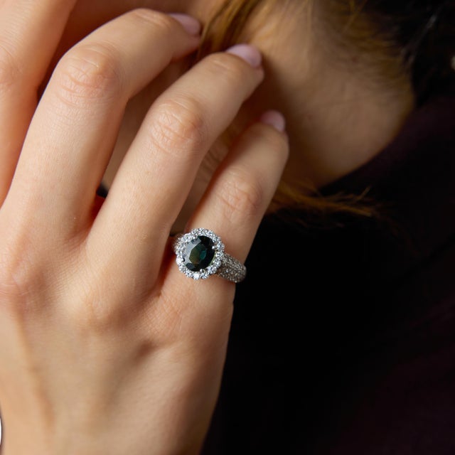 A striking vintage ring centered around a beautiful 1.88 carat oval cut green sapphire, whose rich and uncommon hue gives...