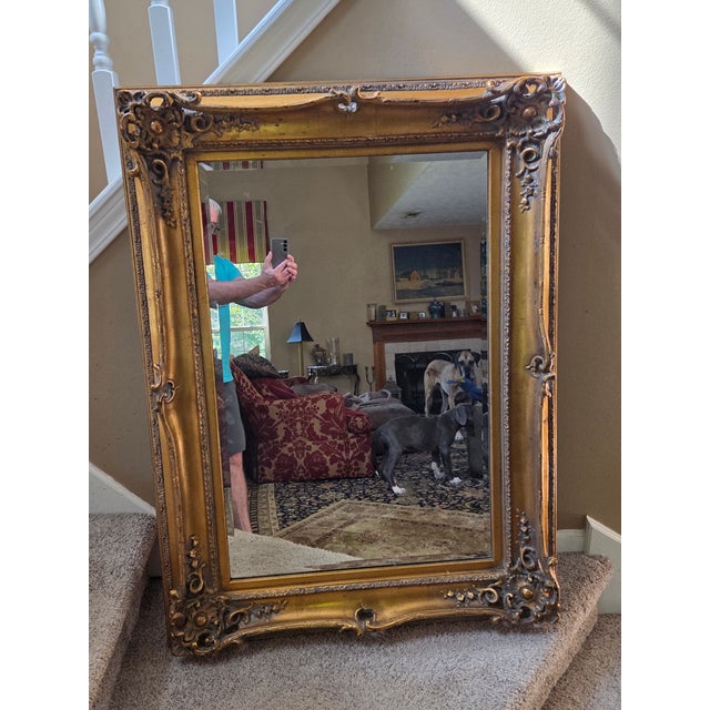 This extraordinary gilt ornately carved wood frame Mirror, 47" x 35" and can be hung horizontally or vertically.