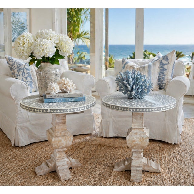 Pair of round side tables featuring intricate hand-applied inlay tops and coordinating apron details. Raised on...