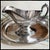 "An elegant vintage silver-plated gravy boat featuring a paneled, multi-faceted body by the renowned silversmiths Reed &...