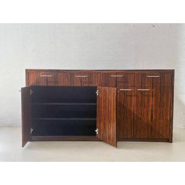 Elegant vintage sideboard with a high-quality veneer in a striking Makassar wood look. The clean lines and the richly...