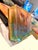 Inner Light presents a translucent, ethereal face emerging from a vibrant interplay of colors and textures. The layered...
