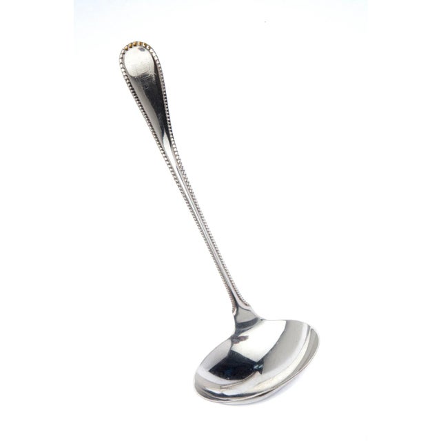 Monogrammed ladle with graceful curves & a fine beaded edge. The monogram is barely visible, for the hallmark; see images.