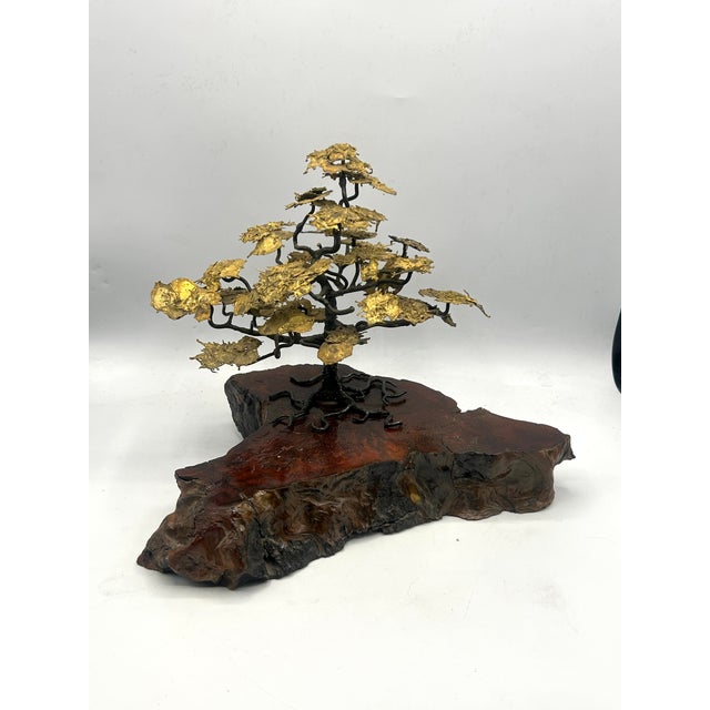 A mid-century tabletop bonsai sculpture featuring dark, gnarled bronze branches and richly textured gilt foliage, mounted...