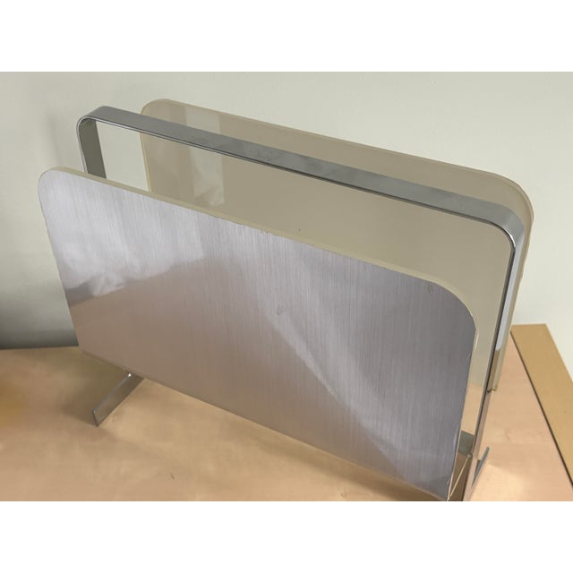 This 1970s Mid-Century Modern magazine rack, attributed to Milo Baughman, showcases a sleek combination of lucite and...
