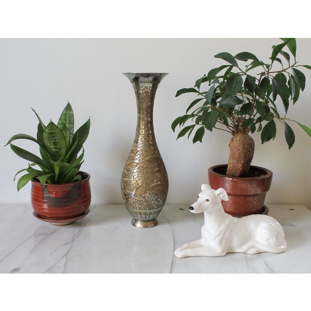 Vintage hand-etched brass vase from India, featuring a slender neck and a flared rim with intricate floral patterns....