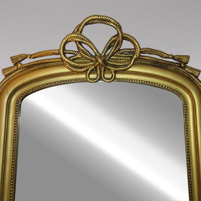 Louis Philippe style gilt mirror, adorned with a pretty ribbon trim. The mirror is original.