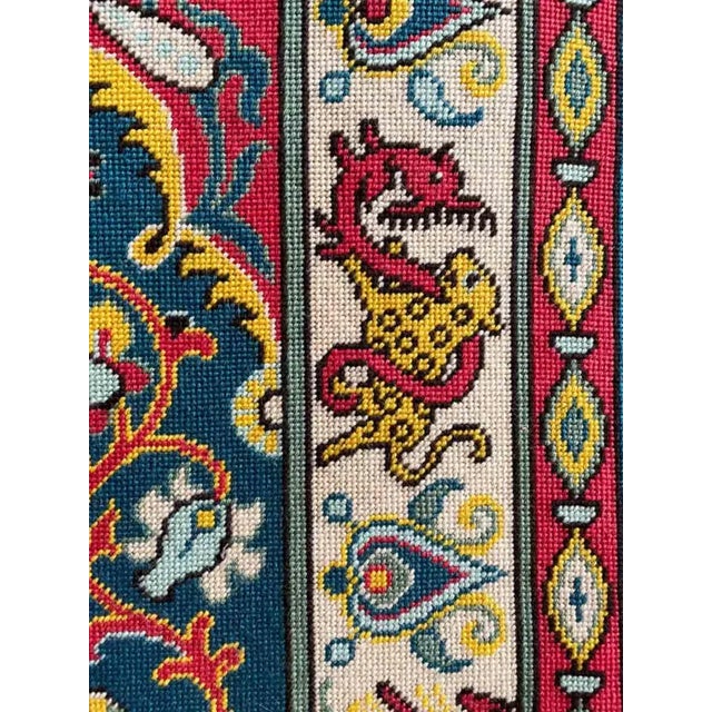 Vintage needlepoint wall hanging with animal design and tassels on upper corners.