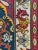 Vintage needlepoint wall hanging with animal design and tassels on upper corners.