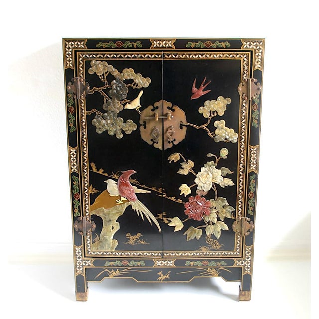 A very high quality and eye catching black lacquer cabinet from China made of carefully and deeply carved hard stone, wood...