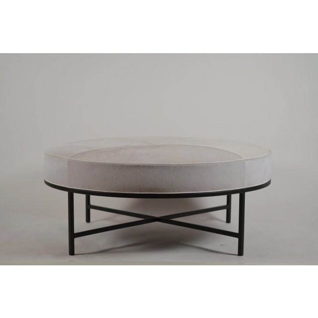 White hide and matte black 'Tambour' round ottoman by Design Frères. Upholstered firm for use as an ottoman / coffee...