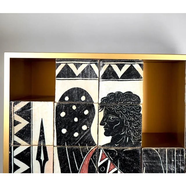 Mythos Apollo storage unit with gold-coloured lacquered wooden structure. Hand decorated on terracotta tiles and with 10...