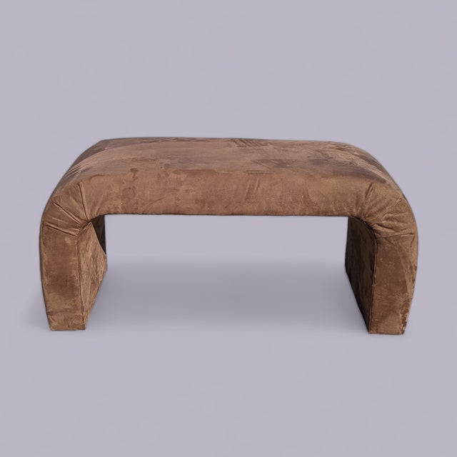A sculptural 1980s waterfall bench fully upholstered in warm brown faux suede. The continuous rounded profile creates a...