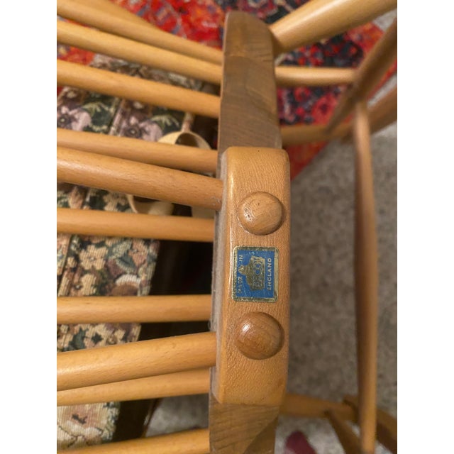 Pristine condition grandfather ‘Windsor’ rocking chair in blond elm and beech with original seat cushion.