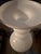 A striking sculptural floor vase in luminous opaque white glass. Its dramatic rounded body, stacked forms, and flared...