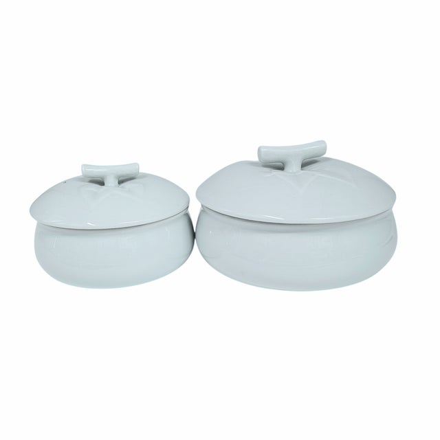 Two bowls, pale as morning frost, with lids shaped like fallen leaves. These celadon vessels feel plucked from a Korean...