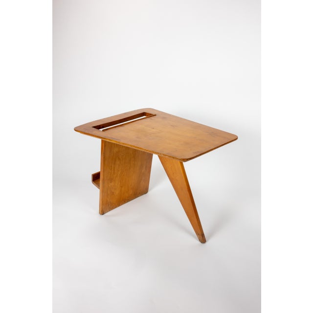 Jens Risom magazine table, model T539, designed in 1949. The rounded, tapered top sits on a single angled slab that passes...