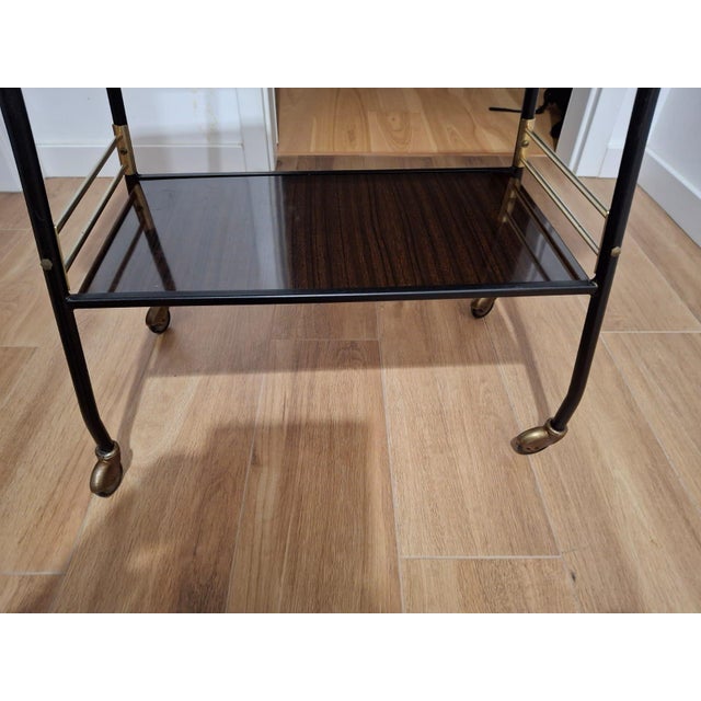 An elegant side table/bar table on casters, designed in the style of French Modernism. The sleek black lacquered metal...