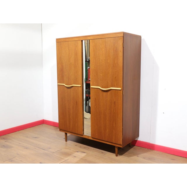 This Mid Century Modern Vintage Teak Triple Armoire Wardrobe by Stonehill in a Danish Style offers a stunning wardrobe...