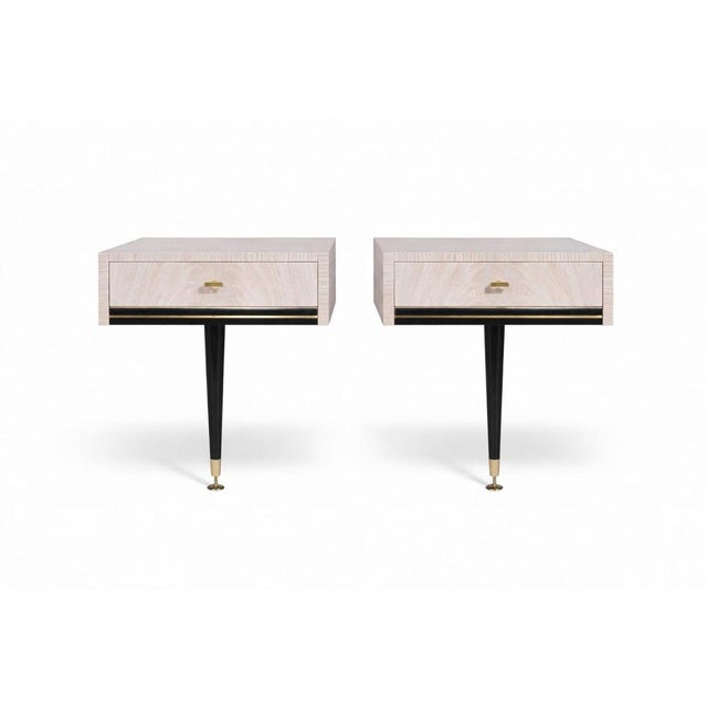 A striking pair of mid-century floating bedside tables, combining elegant light Formica cabinetry with sculptural black...