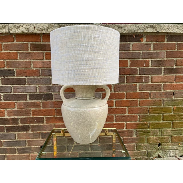 Vintage ceramic and brass water jug lamp with crackle glaze. The color is a pale, warm gray that can read ivory in bright...