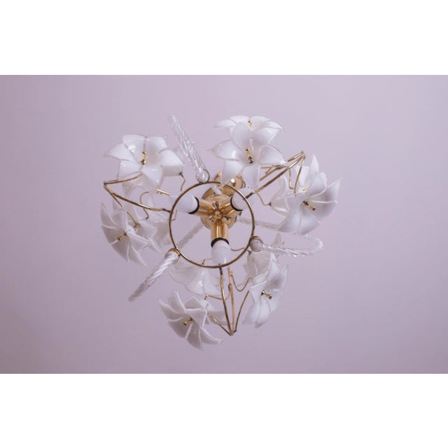 Vintage Murano glass chandelier filled with white flowers. The structure of the chandelier is circular and has three...