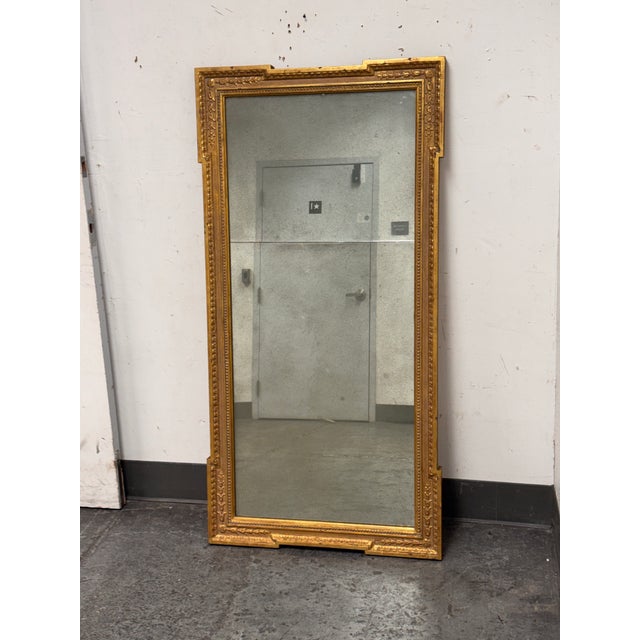 Design Plus Gallery presents a Antique Neoclassical Giltwood Wall Mirror This rectangular mirror showcases an...