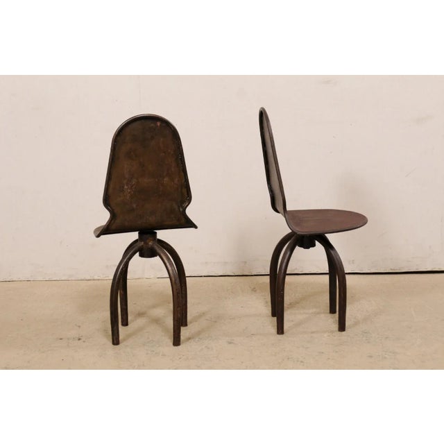 A Spanish pair of iron swivel chairs. This vintage pair of chairs from Spain are fun and quirky! They are constructed from...