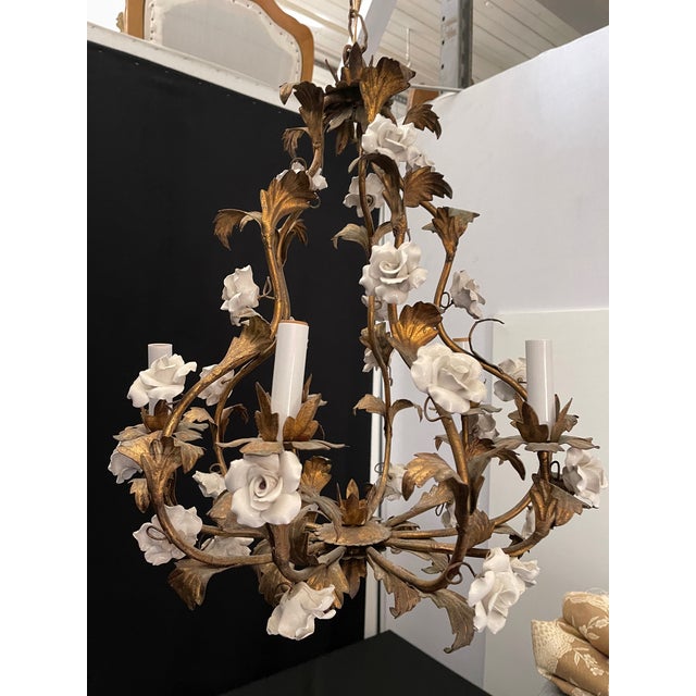 Charming 1950s Italian gold tole birdcage chandelier with 20 white porcelain roses attached throughout. Chandelier comes...