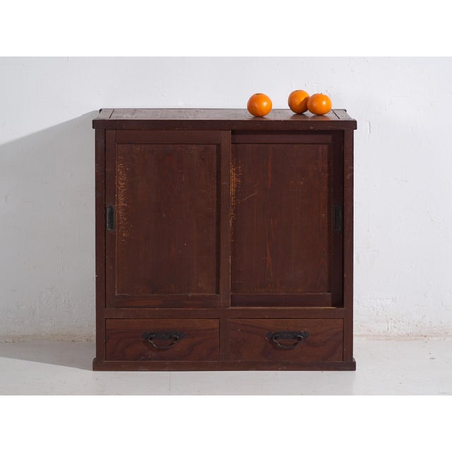 Antique Japanese cabinet with sliding doors and two lower drawers, made of solid wood and dating from the late Taisho to...