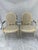 A matching pair of vintage carved wood French Louis XVI style arm chairs with woven cane seat and back. Each chair...