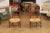 Two rustic French walnut armchairs from the 19th century with scrolling ladder backs, curving open arms, turned supports,...