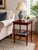 An elegant vintage two-tier side table featuring a rich mahogany-toned wood finish and beautifully compact proportions....