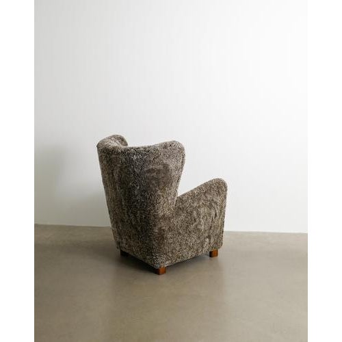 A rare and decorative danish mid century cabinetmaker high wingback and sculptural armchair with sheepskin produced by...