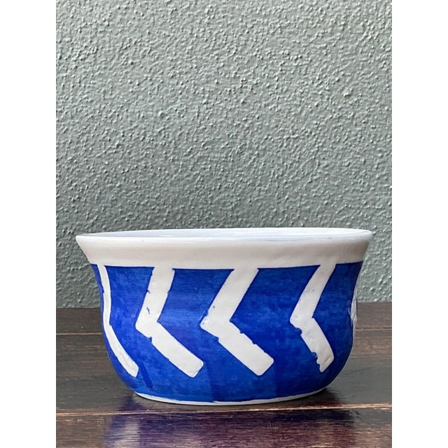 This vintage hand-painted ceramic bowl celebrates the timeless appeal of artisanal craftsmanship with its bold blue-and-...
