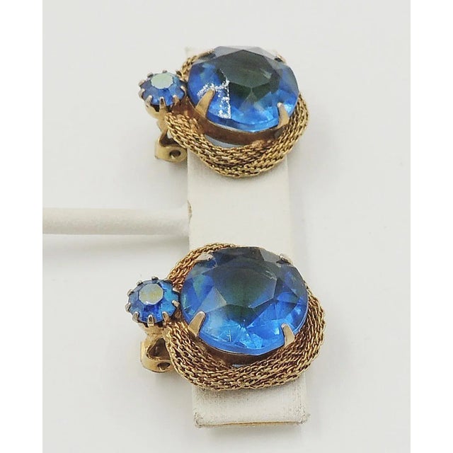 1960s goldtone unfoiled open-backed blue-green rhinestones with blue aurora borealis accent stones clip back earrings....