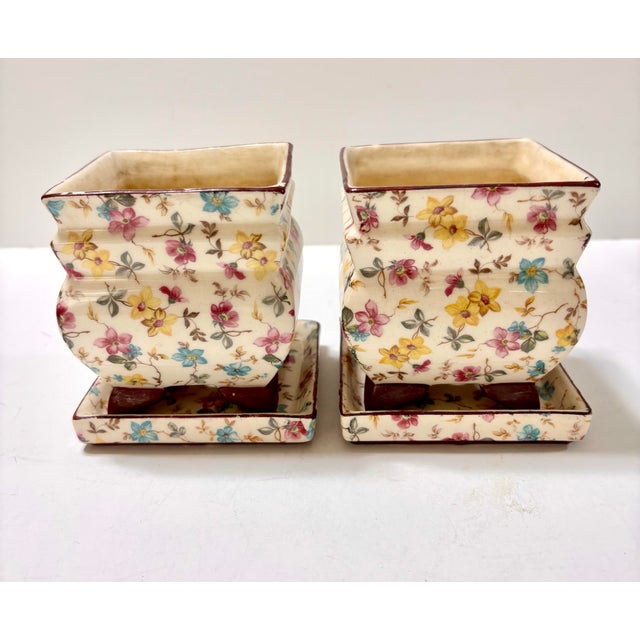 Wonderful vintage set of floral chintz flower pots on matching saucers. The planters feature a distinct tiered molding and...