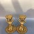 This is a striking vintage pair of gilt bronze candlesticks, each modelled as a kneeling figure holding a lotus-form...