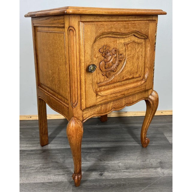 This elegant pair of vintage French Louis-style bedside cabinets showcases graceful lines and refined oak craftsmanship....