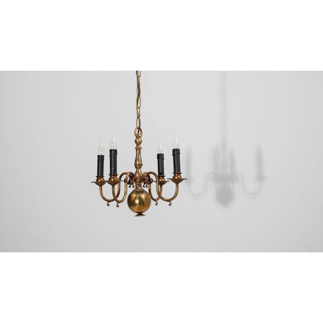 This 20th Century Belgian Colonial Revival brass chandelier blends traditional craftsmanship with timeless elegance....