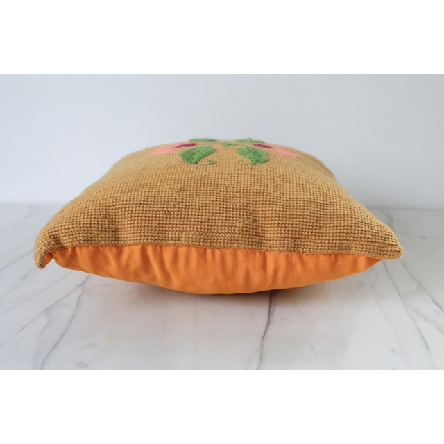 Vintage square needlepoint accent pillow with floral motif. Apricot orange colored backing. No makers mark. Some light age...