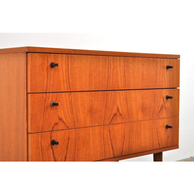 Stylish vintage cabinet with slender legs. 1960s. The cabinet has three drawers with unique handles. In excellent...