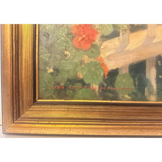 A woman pauses in her garden, shears still in hand, holding a small gathering of warm blooms close. Around her, greens run...