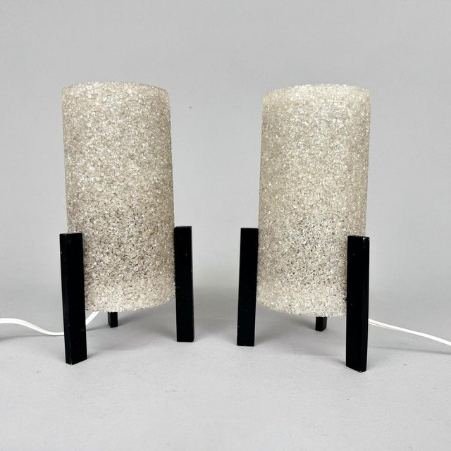 Set of two mid century table or bedside lamps made of plastic and wood. Produced in Germany in the 1970's. Original, fully...