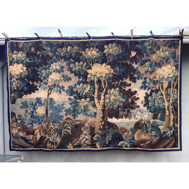This 18th-century French verdure tapestry features a serene woodland scene with two birds gracefully perched on tree...