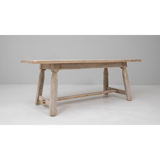 20th century Belgian oak dining table with splayed legs, exemplifying the understated strength and craftsmanship of...