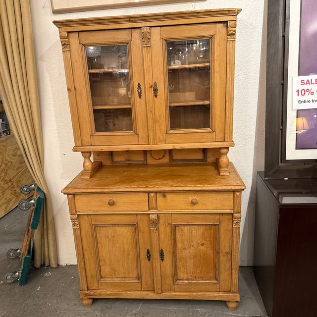 Design Plus Gallery presents an Antique European Pine Two-Piece Hutch Cabinet, Circa 1830. Dating to the early 19th...