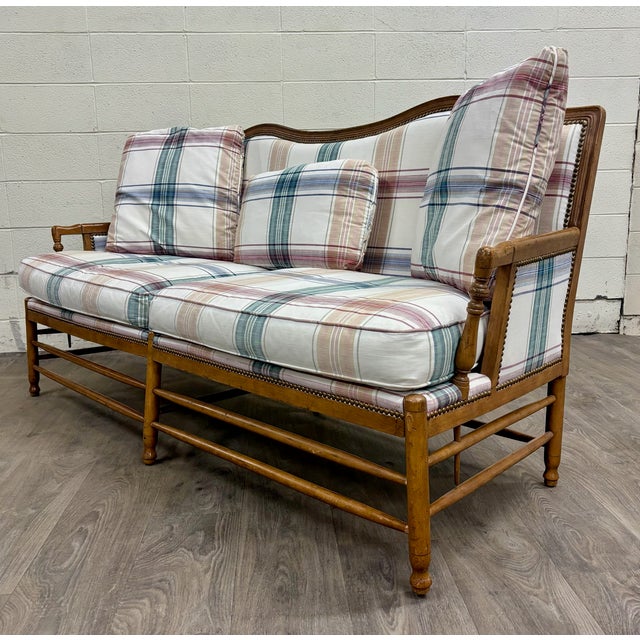 This is a gorgeous vintage mid-century modern Isenhour Furniture Ficks Reed style rattan camelback sofa with brass...