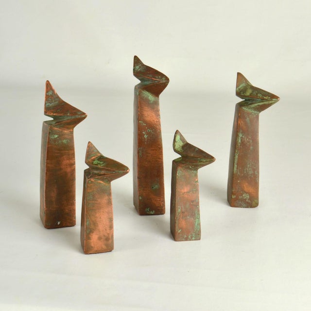 Group of five abstract sculptures in different heights are like a family of figures. They are hand made in copper and...